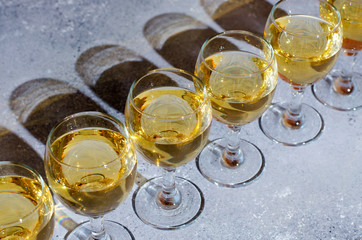 White wine in glass glasses. Blue background. Dark shadows from glasses