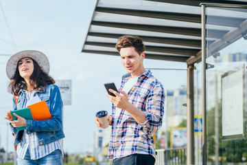 Tourist travelers consulting gps and guide from a smart phone in a train station