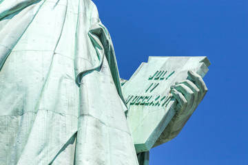 Detail of the Lady Liberty statue, book with the date of USA's independence