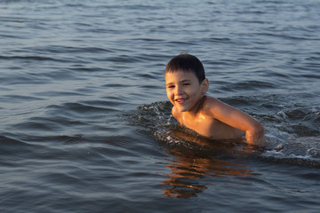 little boy swims in the sea