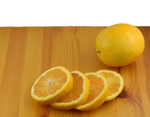 Orange mit vier Orangenscheiben auf einem Kiefernholzbrett, isoliert auf wei&szlig;