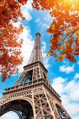 Eiffel Tower against the blue sky and autumn trees in Paris, France. Famous travel destination
