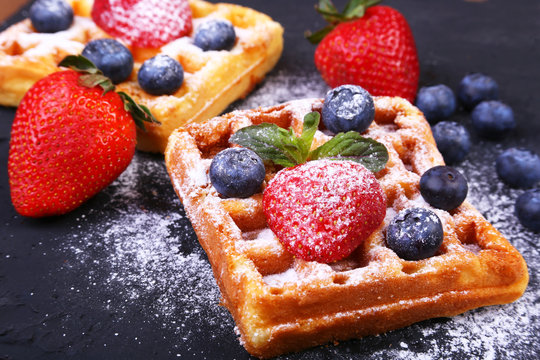 Homemade Traditional belgian waffles with fresh fruit, berries and sugar powder on black plate. - Powered by Adobe