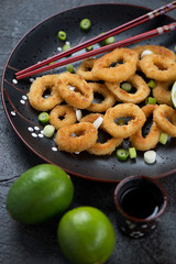 Plate of pan fried calamari rings in panko breading, vertical shot, close-up