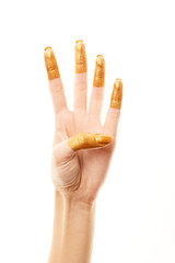 Hands in gold paint. Golden fingers. Female hand is showing numbers isolated on white background. Sign language. Hand numbers