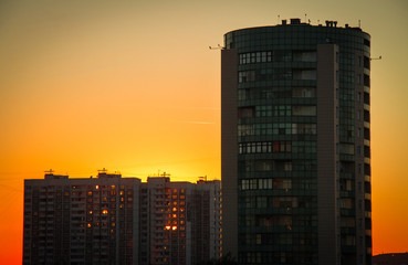 Several residential buildings on a background of orange sunset, Moscow