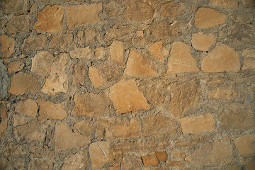Texture background old stone wall. Wall texture of ancient old brick stone. Outdoor exterior castle facade with destroyed uneven pattern of shabby rock.