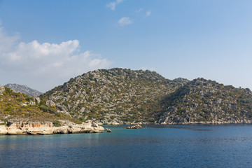 Mediterranean sea overlooking the mountains. Aerial top view of sea waves hitting rocks on the beach with turquoise sea water. Amazing rock cliff seascape in the coastline.
