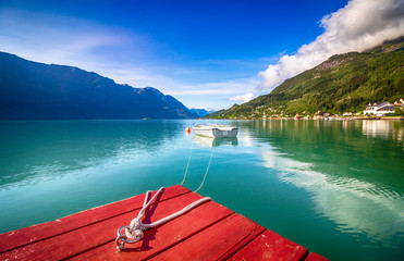 roter Bootsanleger mit Angelboot im Hintergrund, norwegischer Fjord