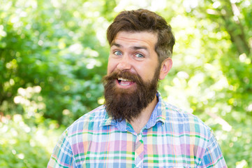 Fototapeta premium Summer vacation concept. Man bearded hipster green trees background. Hike and travel. Guy relax in summer nature. United with environment. Handsome lumberjack. Man beard and mustache in summer forest