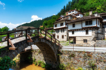 Fototapeta na wymiar Roman Bridge and old houses in of Shiroka Laka village, Smolyan Region, Bulgaria