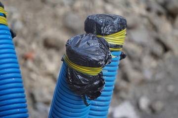 plastic blue water pipes in the city, wrapped to prevent water from getting inside during the...