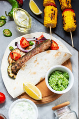 Assorted delicious grilled vegetables and doner kebab on a concrete background. Summer food