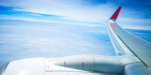Naklejka na ściany i meble Airplane wing over the sky background, view from window
