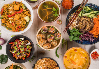 Asian food background with various ingredients on rustic wooden table.
