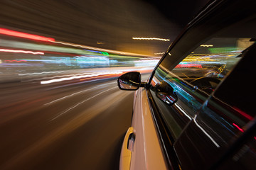 Fototapeta na wymiar Speeding car driving in a night city.