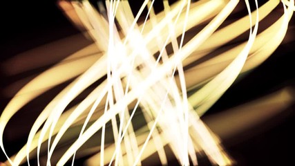 Abstract neon wavy yellow lines flowing on black background, seamless loop. Animation. Shining golden curved stripes with light flares moving slowly. - Powered by Adobe