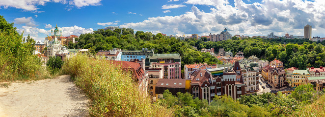 Fototapeta na wymiar Panorama of historical part of Kyiv city with Andriivska church on Andriyivskyy descent, Vozdvyzhenka with ancient colorful buildings, Ukraine
