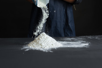 An experienced chef in a professional kitchen prepares flour dough to make Italian Italian pasta.