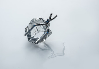 Ice cube tied with wire, but it melts and runs away