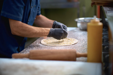 Chef prepares focaccia bread pizza baked in the oven at the market