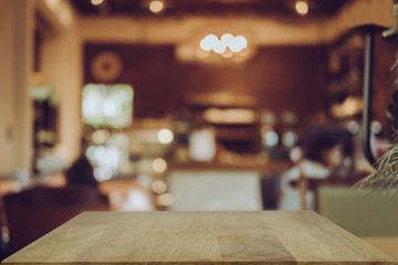 Empty wooden table blurred of restaurant cafe background and reception room, can be used for display or montage your products