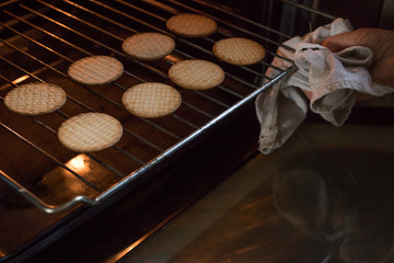 removing freshly baked cookies in the oven