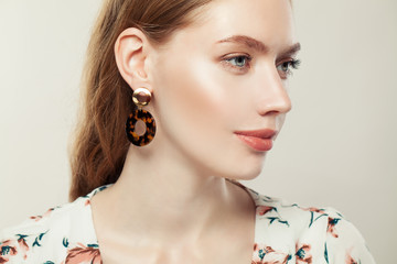 Jewelry woman wearing fashion golden earrings on white background, elegant female profile