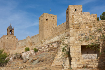 Fototapeta na wymiar The Walls, Towers and Keep of the Alcazaba of Antequera, perched high above the Town on a Rocky Sandstone outcrop.