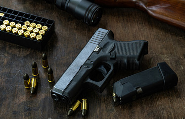 Guns and ammunition on the wooden table, top view and free space for entering your text.