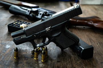 Guns and ammunition on the wooden table, top view and free space for entering your text.