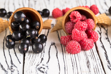 Summer berries in waffle cone on wooden background.