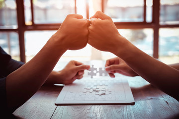 Closeup hand of business people connecting jigsaw puzzle with sunlight effect, Business solutions...