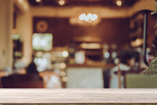 Empty wooden table blurred of restaurant cafe background and reception room, can be used for display or montage your products