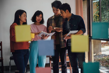 Asian business people meeting new startup project pointing graph discussion and analysis data charts and graphs.Business finances and accounting concept