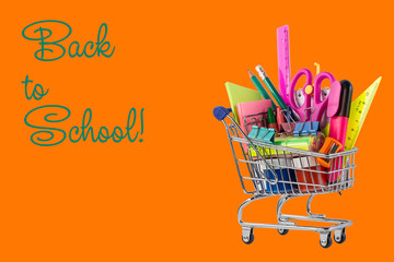Shopping cart with different stationery on an orange background