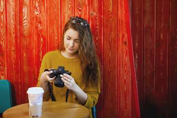 Beautiful young woman using her digital camera in cafe. © olgasparrow
