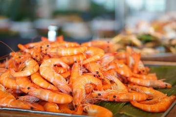 steamed banana shrimp or banana prawn orange serve on wood tray and banana leaf for lunch or dinner on seafood buffet restaurant at hotel with warm light on delicious food with space
