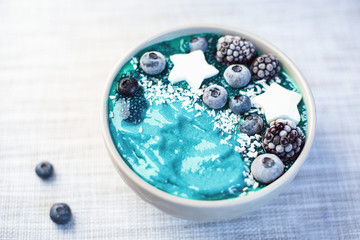 Healthy breakfast berry, banana smoothie bowl topped with Blueberries and chia seeds , blackberries coconut delicious blueberry smoothie bowl. vegan raw food. Selective focus. copy space