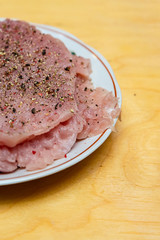 fresh meat thin seasoned stack raw schnitzel close-up on a wooden table
