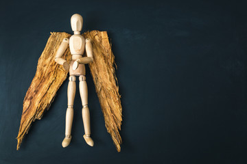 Wooden angel on black background with copy space
