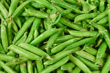 Fresh pea pods as background. Top view.
