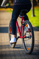 Naklejka premium Urban biking - woman riding bike in city park