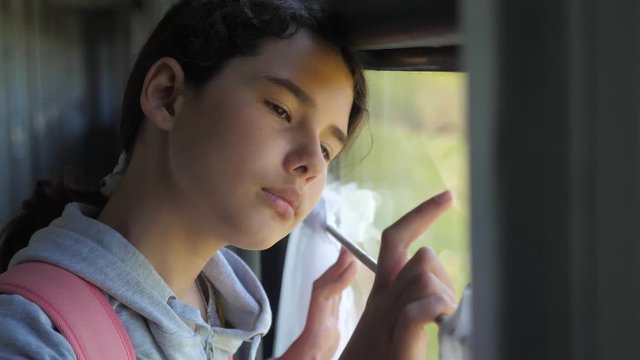 sad girl looks out the train window. travel transportation railroad concept. lifestyle teen girl misses traveling in a train compartment looking out the window. long train journey by rail