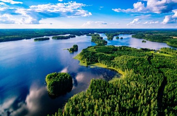 Aerial view of blue lakes and green forests on a sunny summer day in Finland from above - obrazy, fototapety, plakaty