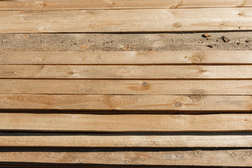 Naklejka premium wooden planks lie in rows. a pile of wooden slats for the floor or ceiling are on the ground. wooden planks with knots as a background