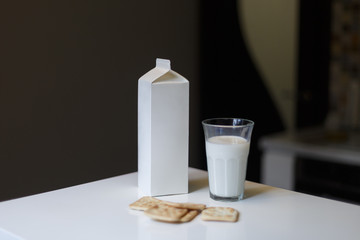 Carton box and glass of milk on table in kitchen