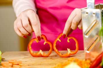 Woman showing sliced red bell pepper rings
