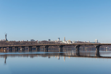 Fototapeta na wymiar view of the right bank of Kyiv, the Dnieper River and the Paton Bridge. Paton Bridge is one of the bridges across the Dnieper in Kiev, early spring day. Panoramic View to the right bank of Kyiv.