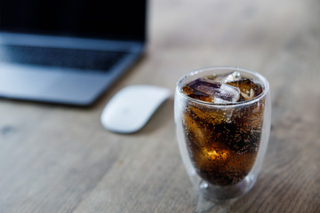 glass of cola with ice on a background